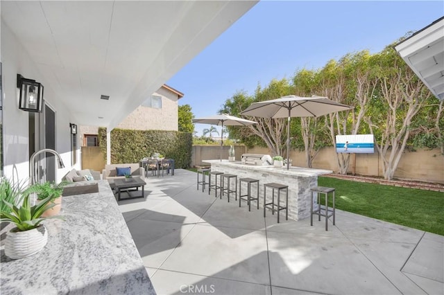 view of patio / terrace with area for grilling, outdoor dry bar, fence, outdoor lounge area, and a sink