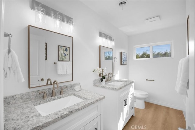 bathroom with vanity, hardwood / wood-style floors, and toilet