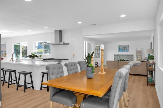 dining space with visible vents, a fireplace, light wood-style flooring, and recessed lighting