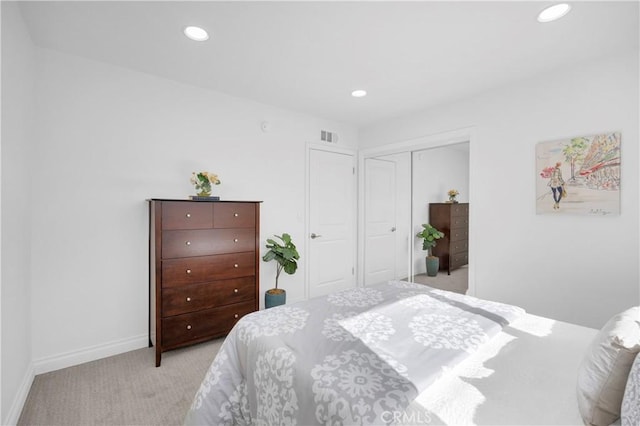 bedroom with recessed lighting, a closet, light carpet, and visible vents