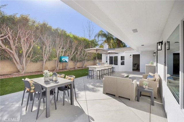 view of patio featuring outdoor dry bar, outdoor dining space, an outdoor hangout area, and a fenced backyard