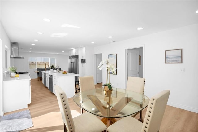 dining area featuring sink and light hardwood / wood-style flooring