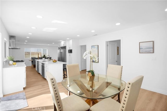 dining area with baseboards, light wood-type flooring, and recessed lighting