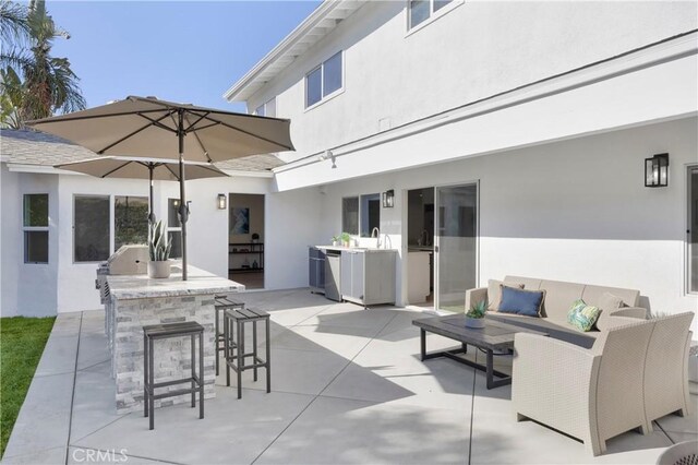 view of patio featuring an outdoor wet bar, an outdoor living space, and an outdoor kitchen