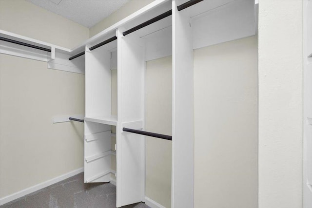 spacious closet featuring dark carpet