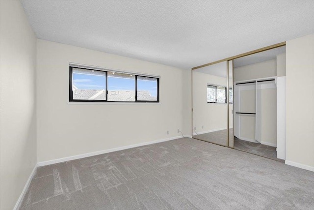 unfurnished bedroom featuring carpet floors, a textured ceiling, and a closet