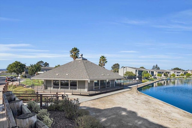 rear view of house featuring a water view and a patio area