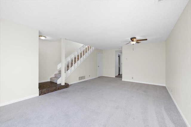 unfurnished living room with a textured ceiling, ceiling fan, and carpet flooring