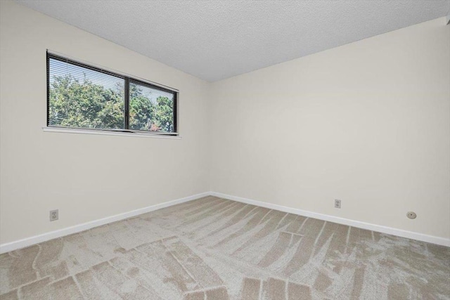 empty room with light carpet and a textured ceiling