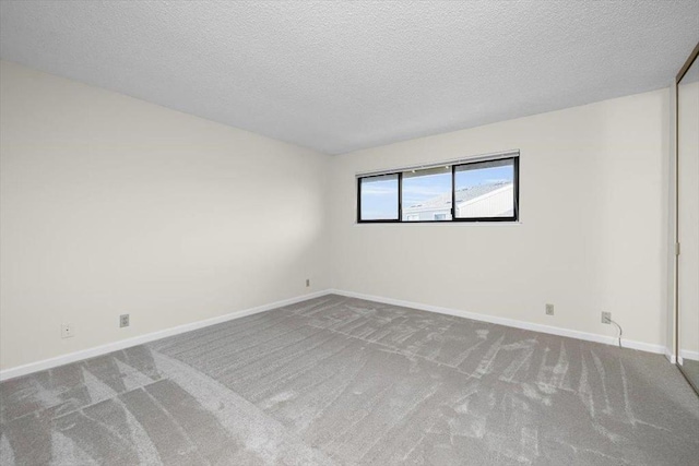 spare room featuring carpet floors and a textured ceiling