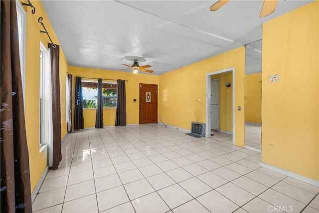 tiled spare room with ceiling fan