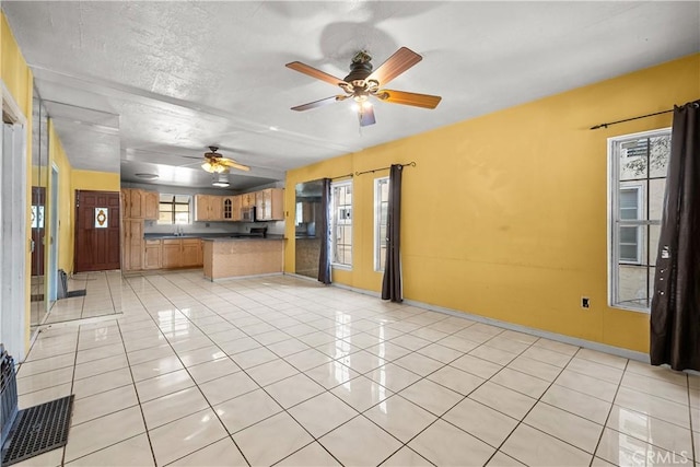 kitchen featuring light tile patterned floors, kitchen peninsula, a textured ceiling, and ceiling fan