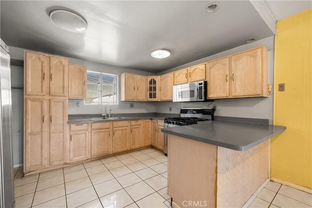 kitchen featuring light brown cabinetry, sink, stainless steel appliances, and kitchen peninsula