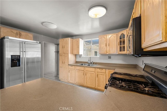 kitchen with stainless steel appliances, sink, and light brown cabinetry