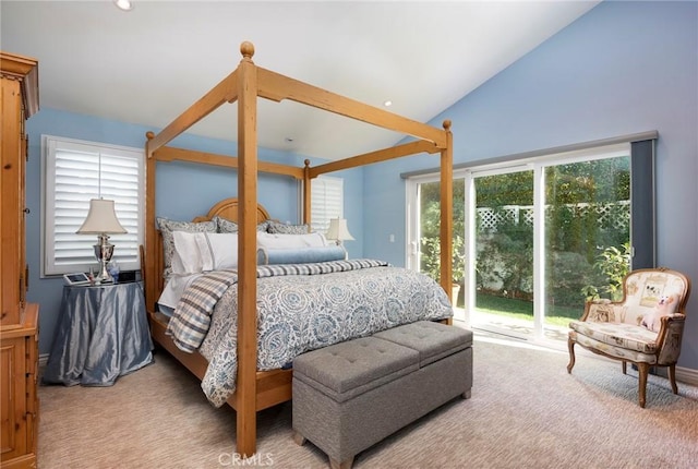 carpeted bedroom with vaulted ceiling and access to outside