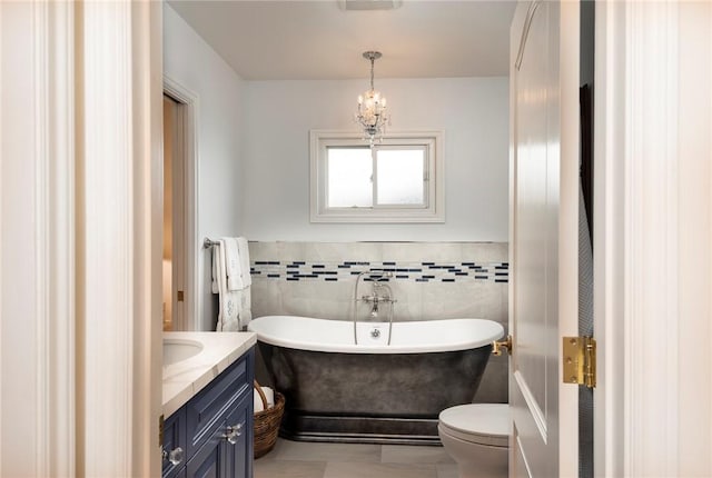 bathroom featuring vanity, toilet, tile walls, and a tub