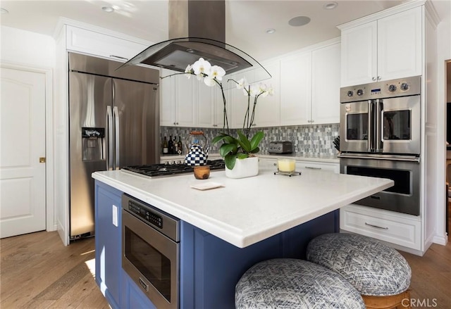 kitchen with island exhaust hood, a kitchen island, and white cabinets