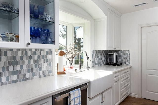 bar featuring tasteful backsplash, sink, and white cabinets