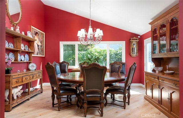 dining area with lofted ceiling, light hardwood / wood-style flooring, and a chandelier