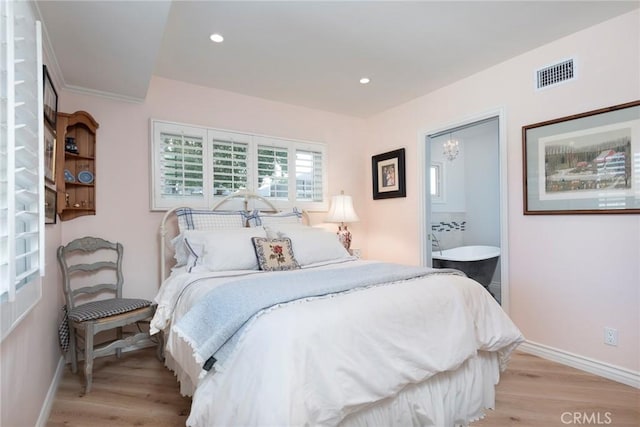 bedroom featuring ensuite bathroom and light hardwood / wood-style floors