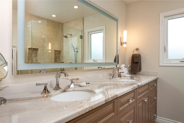 bathroom featuring vanity, a shower with door, and a healthy amount of sunlight