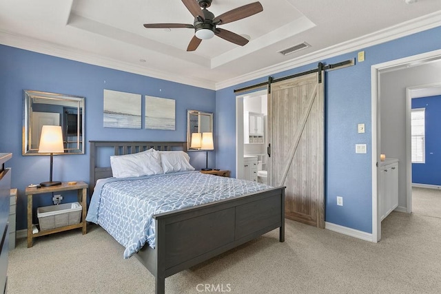 bedroom with a tray ceiling, light colored carpet, and a barn door