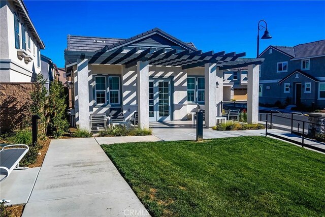 view of front of property with a pergola, a front lawn, and a patio