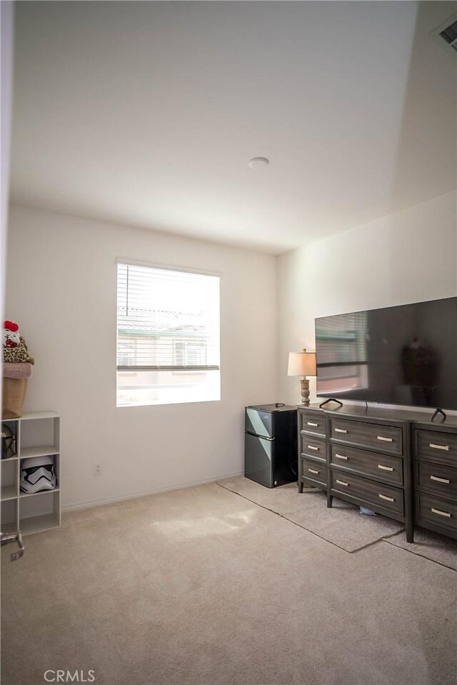 carpeted bedroom featuring black fridge