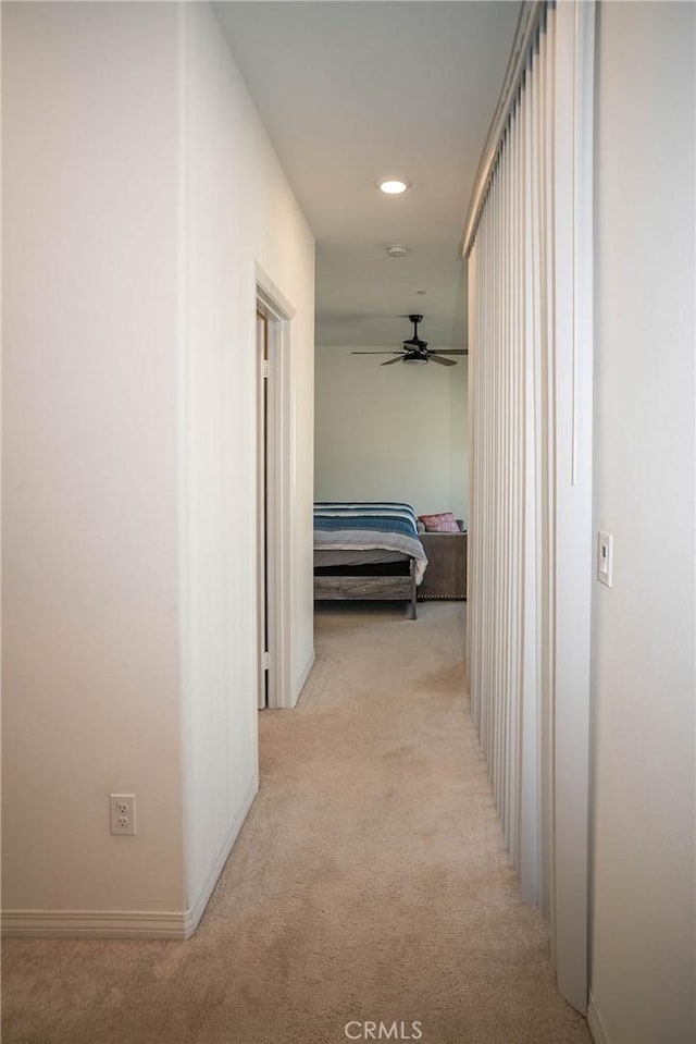 corridor featuring light colored carpet