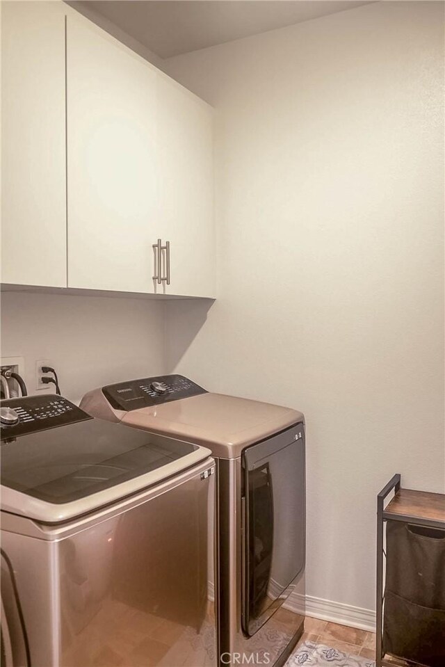 washroom featuring cabinets, independent washer and dryer, and light hardwood / wood-style floors