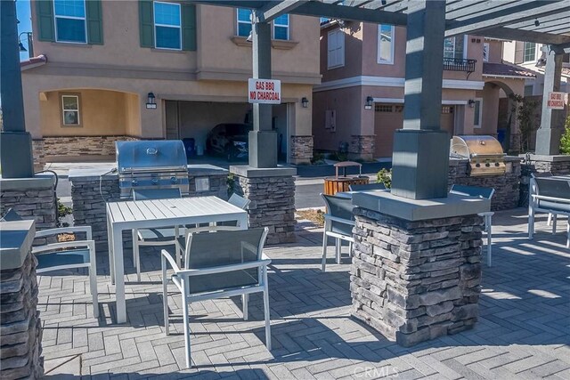 view of patio / terrace featuring a grill, an outdoor bar, and an outdoor kitchen