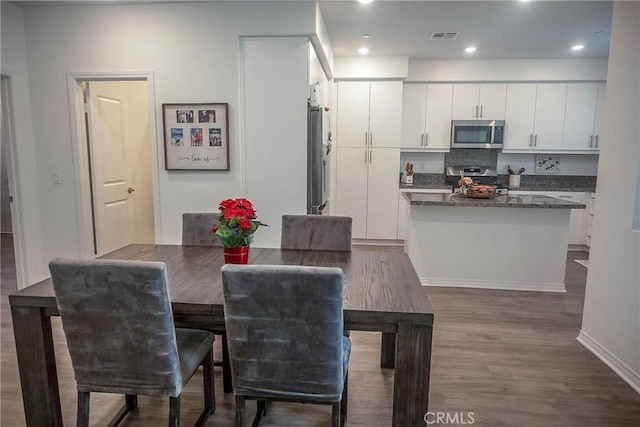 dining space with dark wood-type flooring