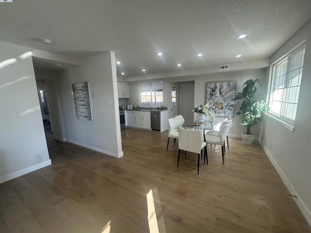 unfurnished dining area featuring wood-type flooring and a textured ceiling