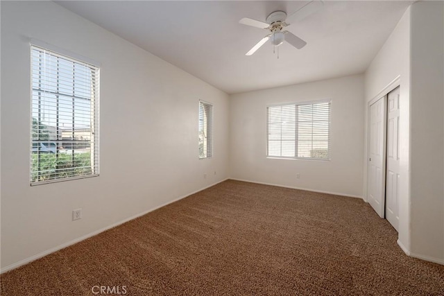 unfurnished bedroom featuring carpet floors, ceiling fan, and a closet