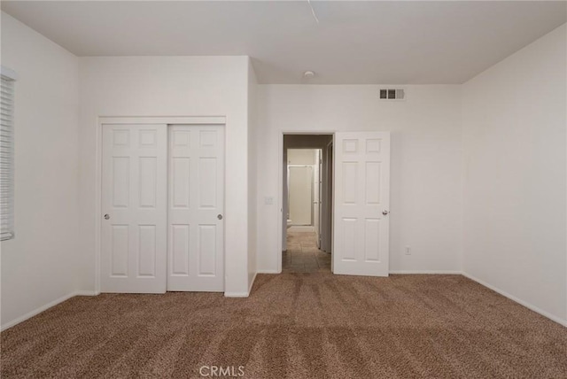 unfurnished bedroom featuring a closet and carpet flooring