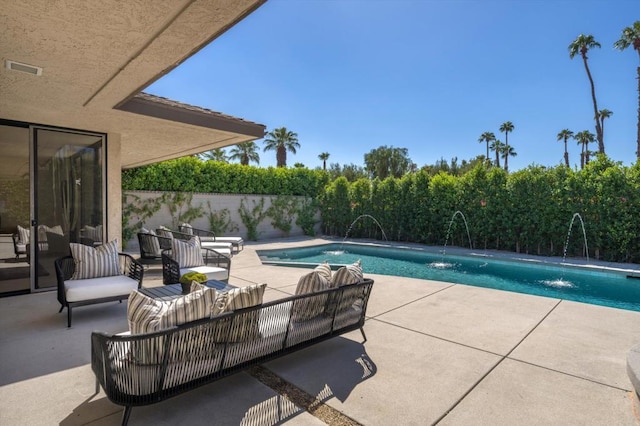 view of swimming pool with pool water feature, an outdoor living space, and a patio