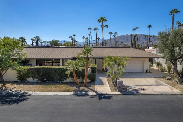 single story home featuring a mountain view and a garage