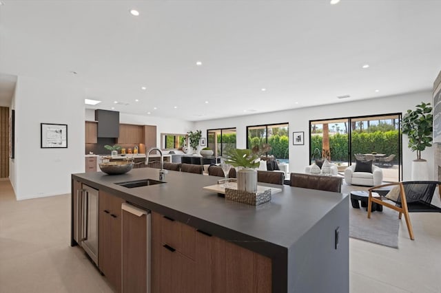 kitchen featuring a kitchen island with sink, sink, and light tile patterned floors