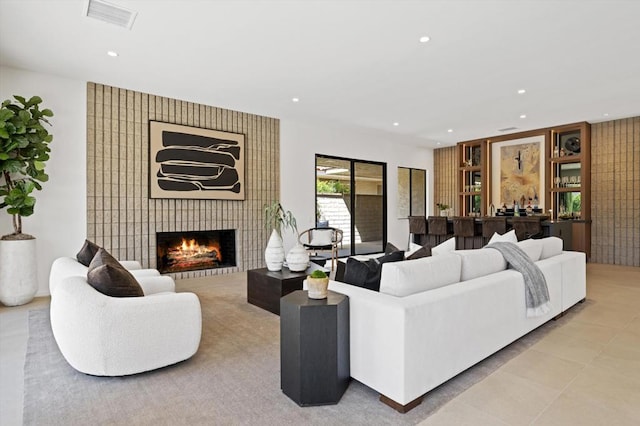 living room with a tiled fireplace and light tile patterned floors