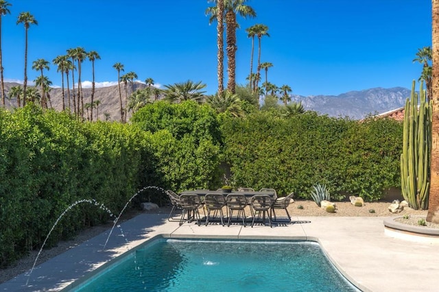 view of swimming pool with a mountain view and a patio