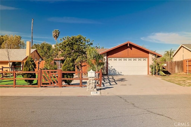 view of front of property featuring a fenced front yard, concrete driveway, and a gate