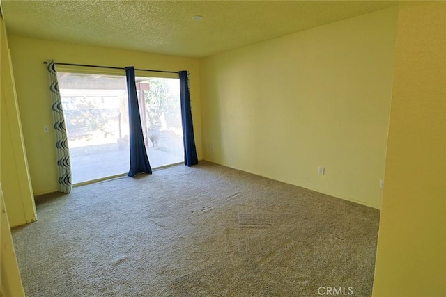 empty room featuring a textured ceiling and carpet flooring