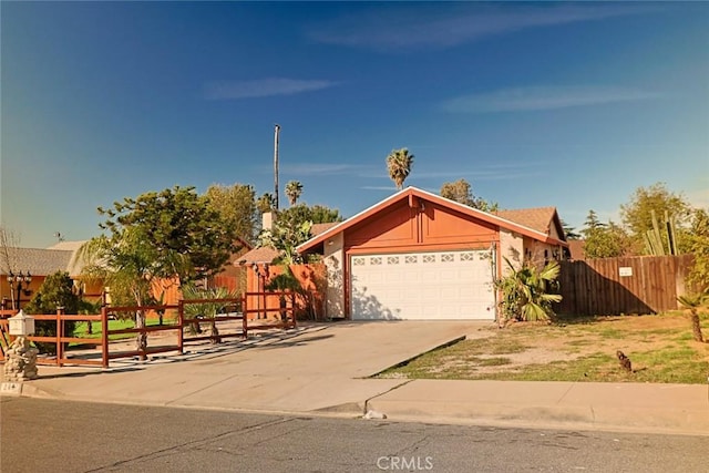 view of front of property featuring a garage, fence, and driveway