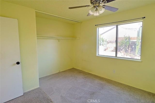 unfurnished bedroom featuring baseboards, a ceiling fan, carpet, a textured ceiling, and a closet