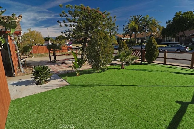 view of property's community with fence and a yard