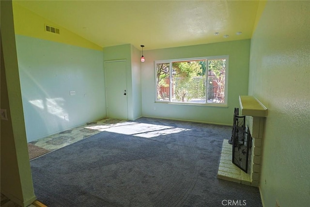 spare room featuring vaulted ceiling, carpet, and visible vents