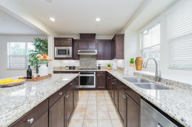 kitchen featuring light tile patterned flooring, appliances with stainless steel finishes, sink, and light stone counters