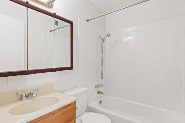 full bathroom with vanity, tiled shower / bath, and toilet