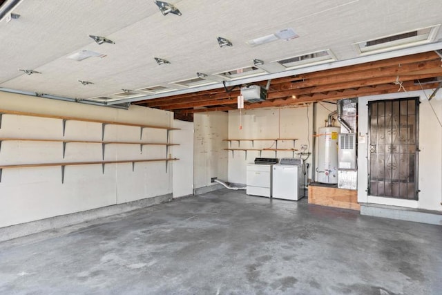 garage featuring washing machine and clothes dryer, a garage door opener, and water heater