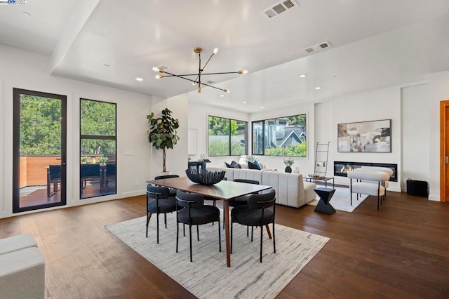 dining space featuring hardwood / wood-style flooring, a wealth of natural light, and a chandelier